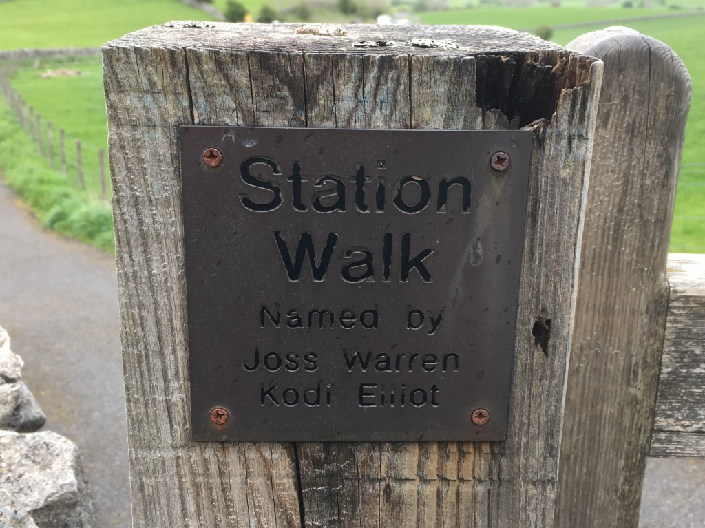 Sign fixed to a gate post: "Station Walk. Named by Joss Warren, Kodi Elliot"